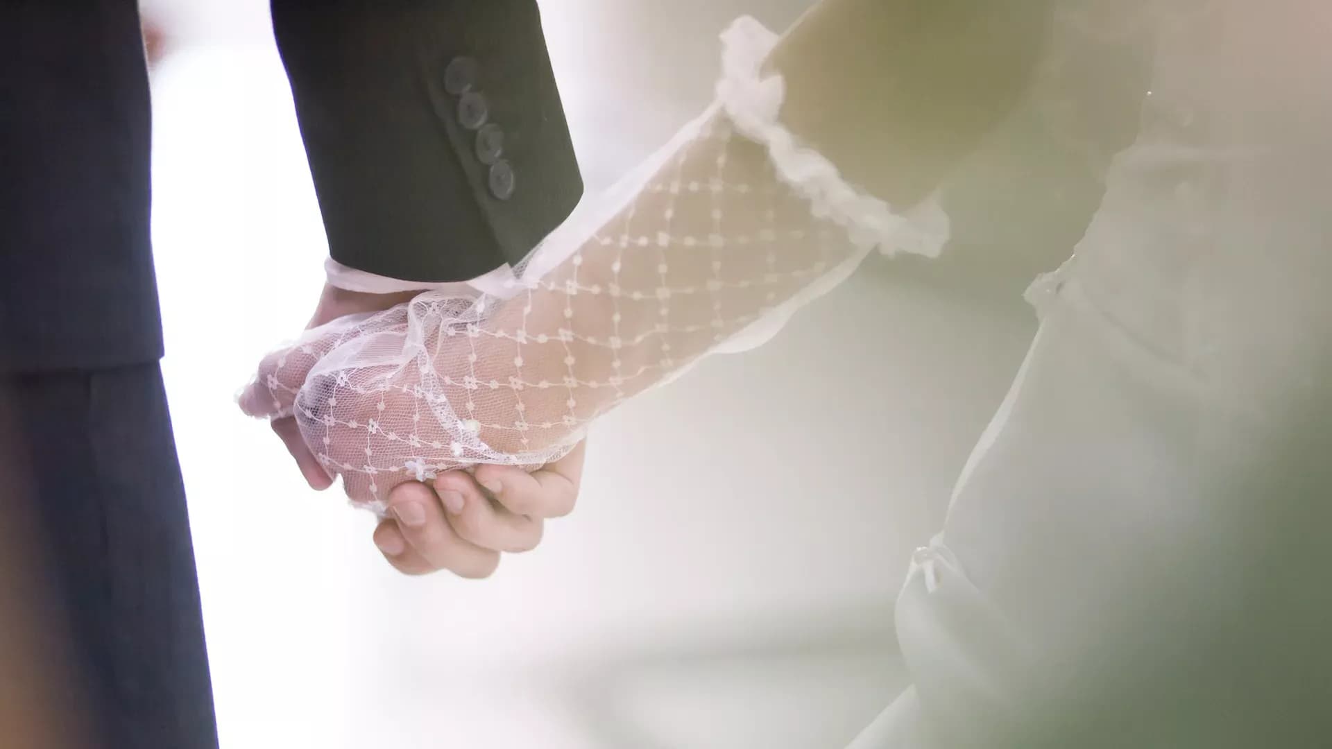 Two hands holding, wedding rings visible